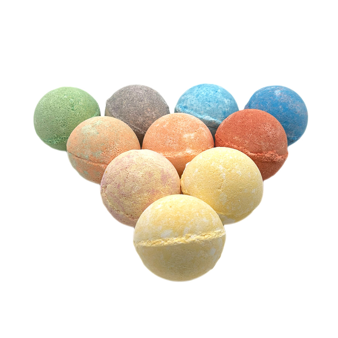 Assorted Dirty Bee bath bombs in green, blue, gray, orange, pink, and yellow on a white background.