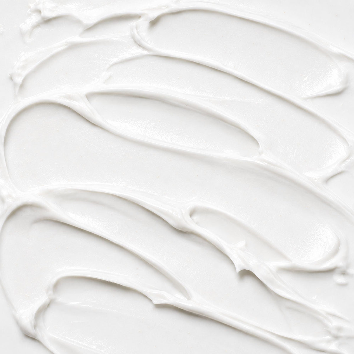 White lotion texture with smooth, creamy swirls and a soft glossy finish.