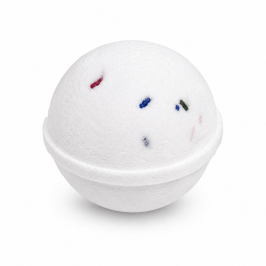 Dirty Bee Cake Pop Bath Bomb, a round white bath bomb with scattered confetti-like flecks in red, blue, green, and pink, on a white background.