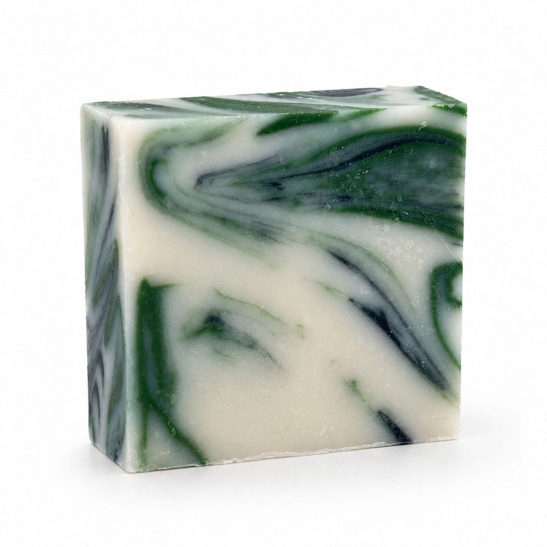 Dirty Bee Clean Dino Soap Bar, a square bar with a marbled swirl of dark green and creamy off-white, on a white background.