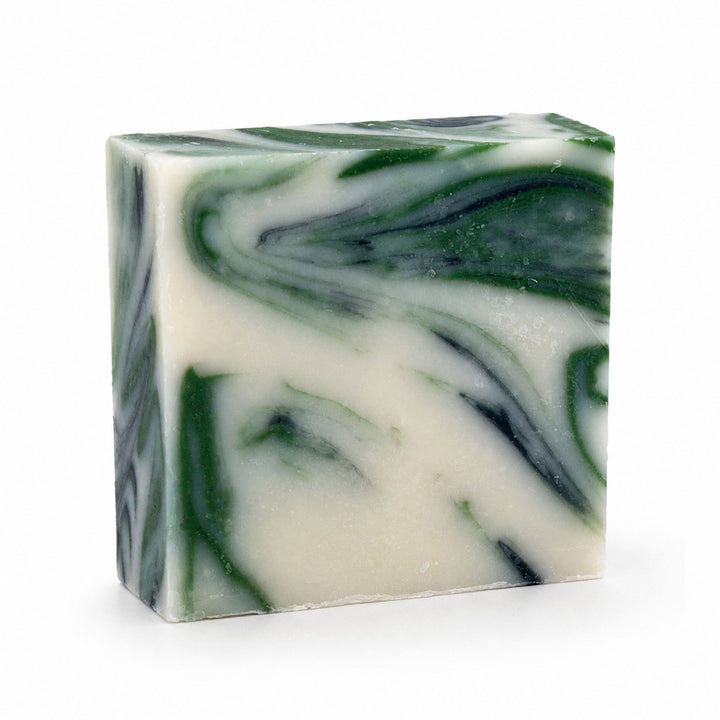 Dirty Bee Clean Dino Soap Bar, a square bar with a marbled swirl of dark green and creamy off-white, on a white background.