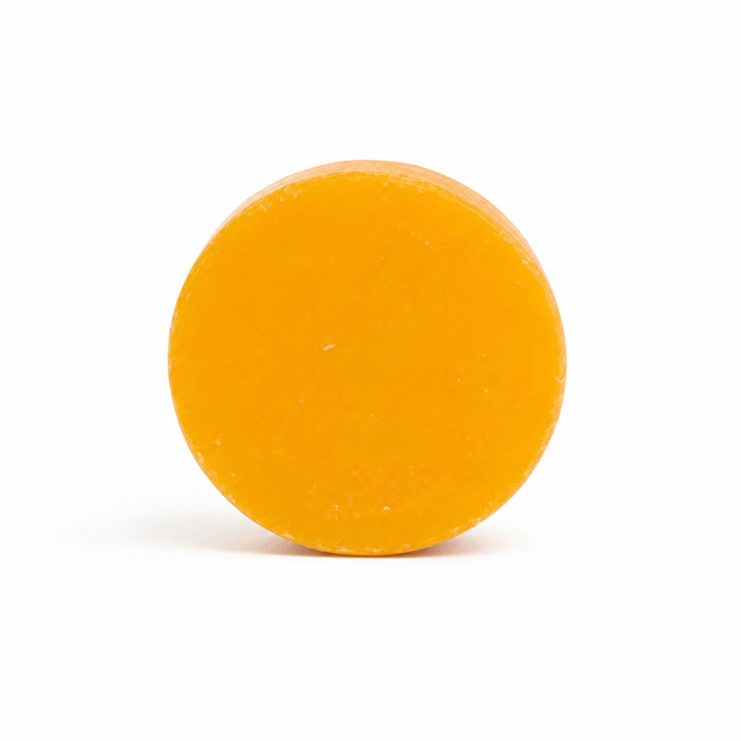 Dirty Bee Florida Fresh Conditioner Bar, a round orange conditioner bar with a smooth surface