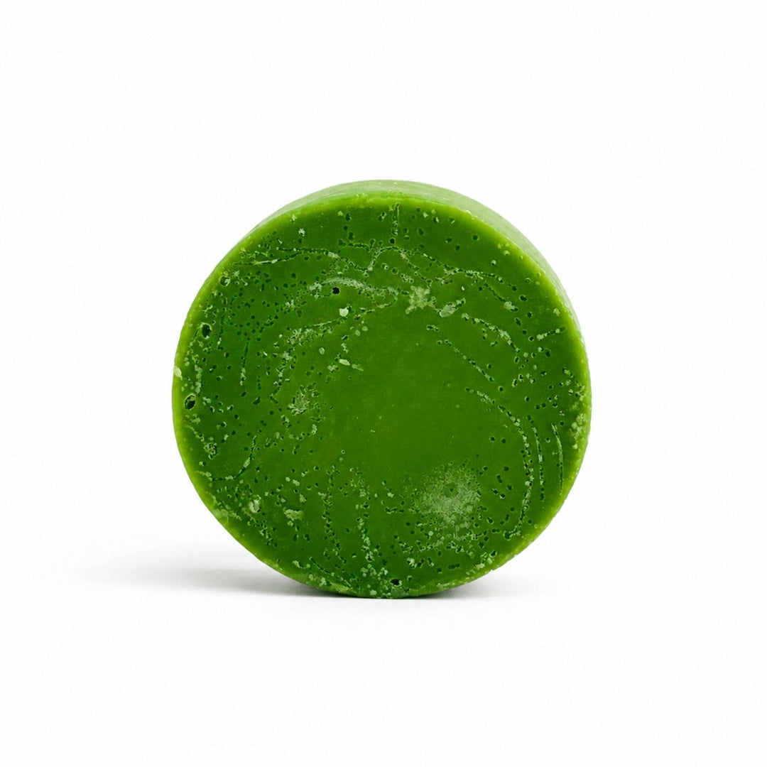 Dirty Bee Frasier Fir Conditioner Bar, a round green conditioner bar with a textured, speckled matte surface