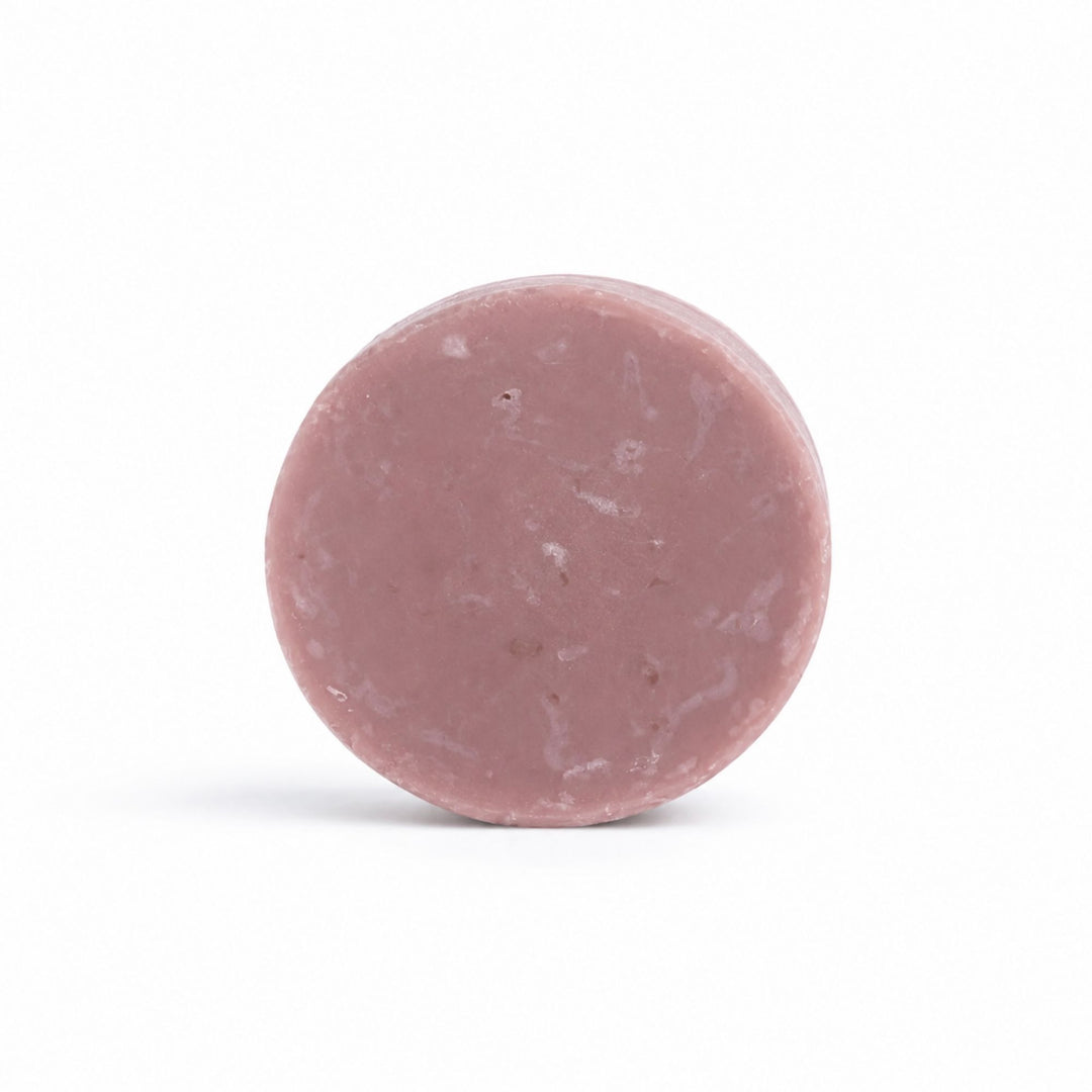Dirty Bee Honey Almond Conditioner Bar, a round dusty rose textured bar on a clean white background.