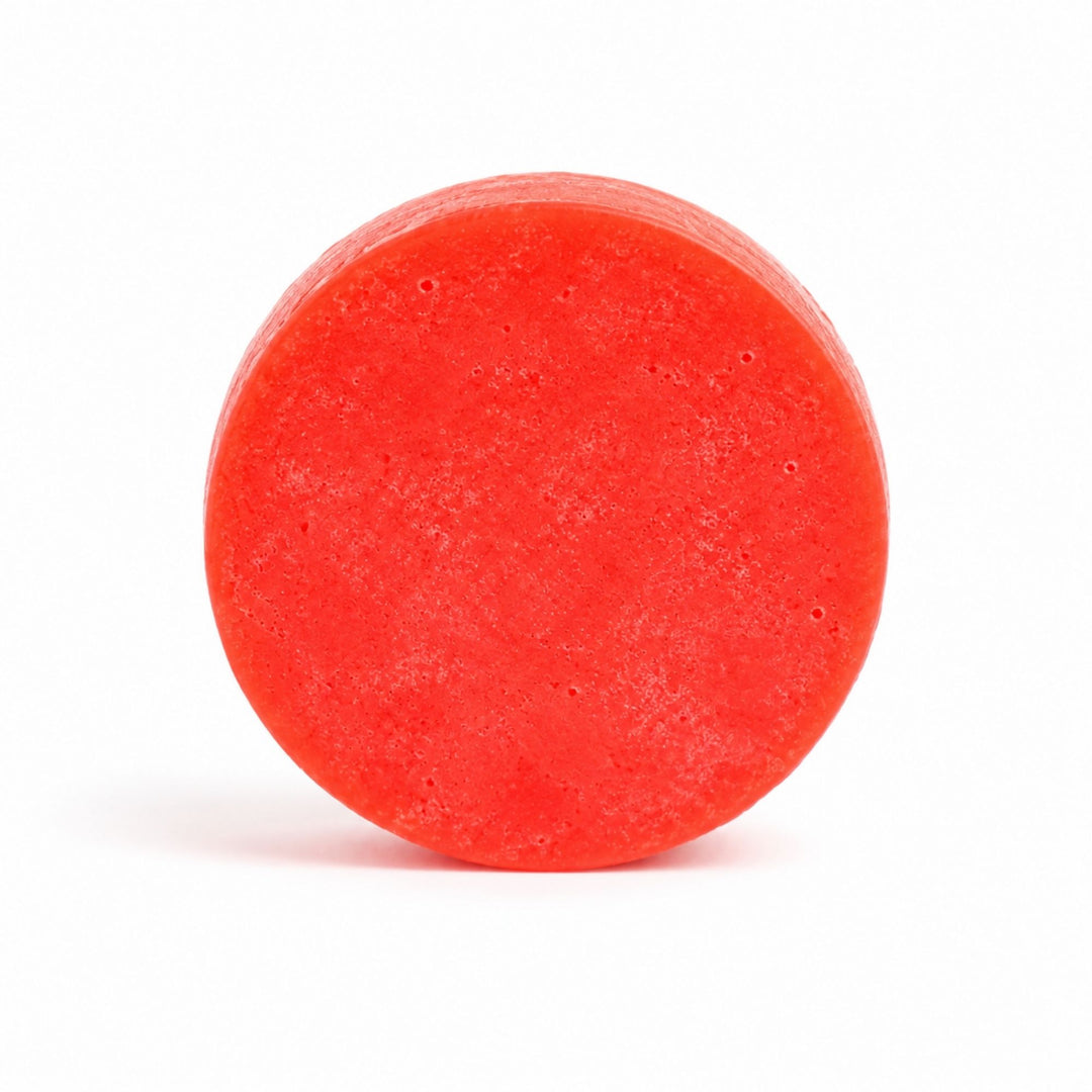 Dirty Bee Pink Sands Conditioner Bar, a round red-orange textured bar on a clean white background.