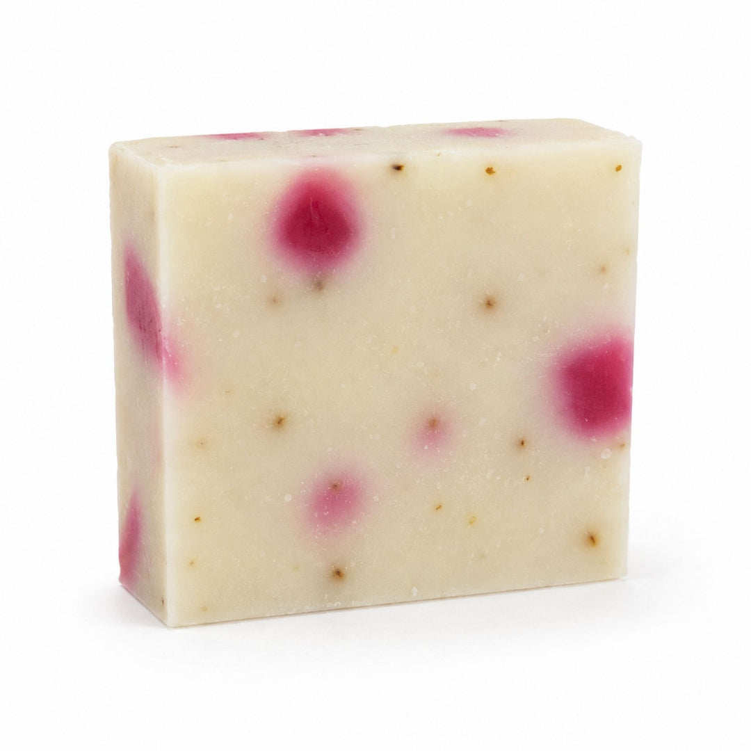 Dirty Bee Pretty Petal Soap Bar, a square creamy off-white bar with pink magenta spots and small brown flecks, on a white background.