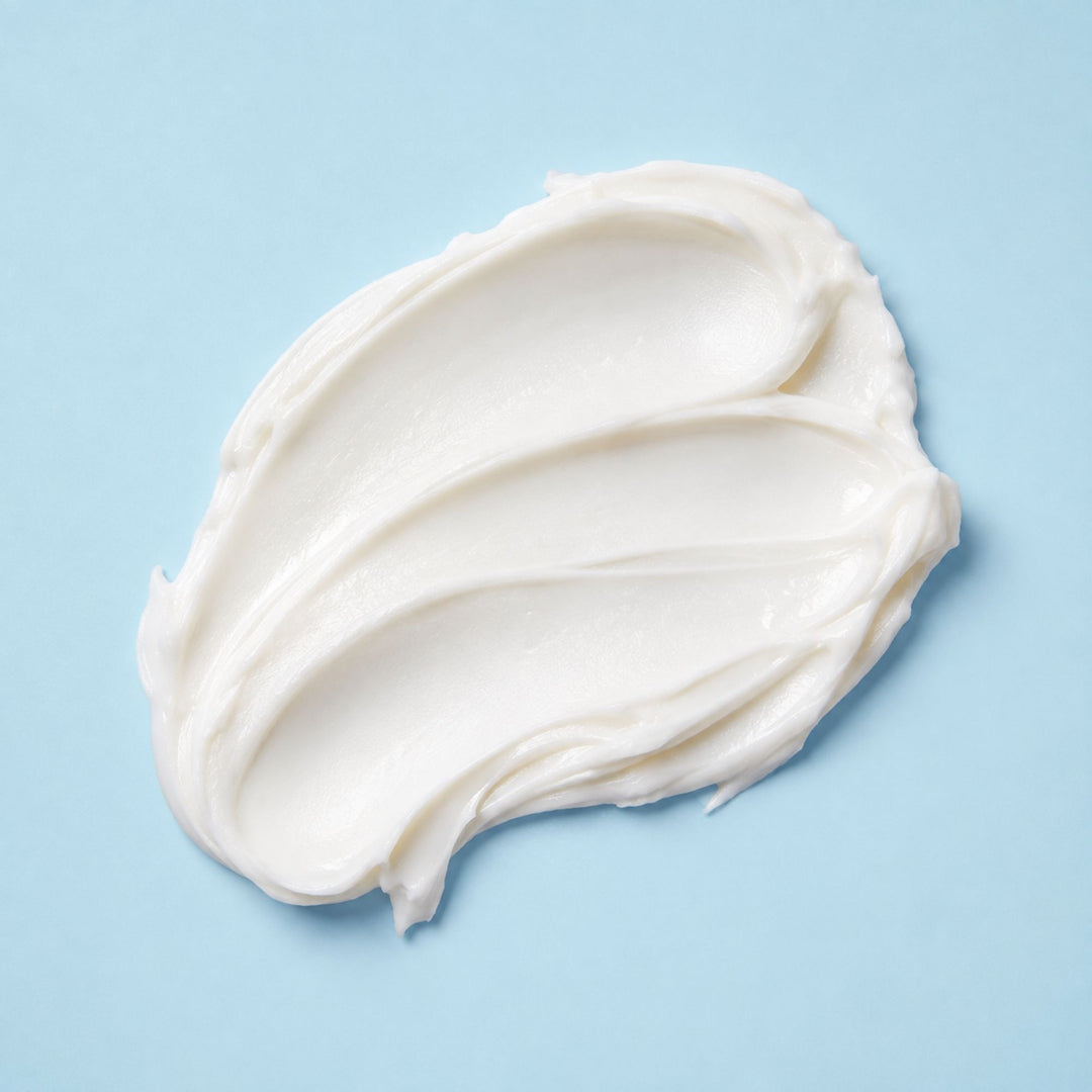 Body Butter swatch with a smooth, creamy texture on a light blue background